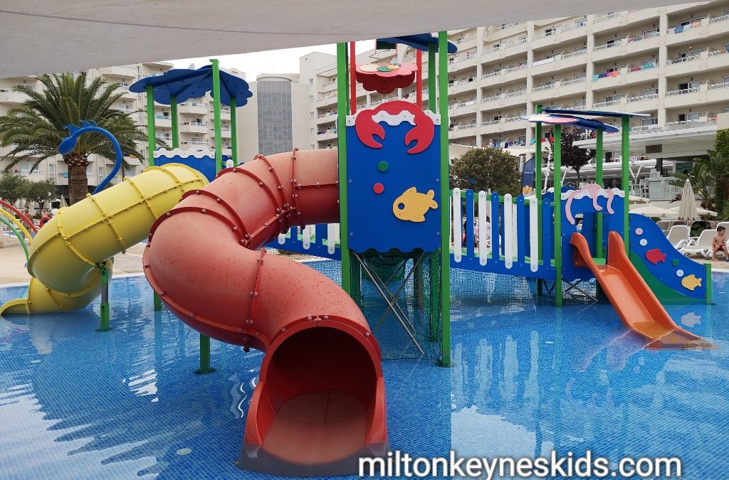 small water slide play area in a paddling pool for young children at the Coma Gran in Sa Coma, Majorca