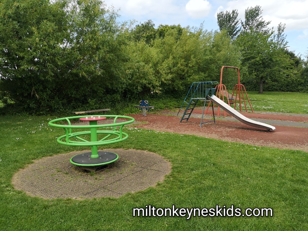 Small green metal roundabout and small slide 