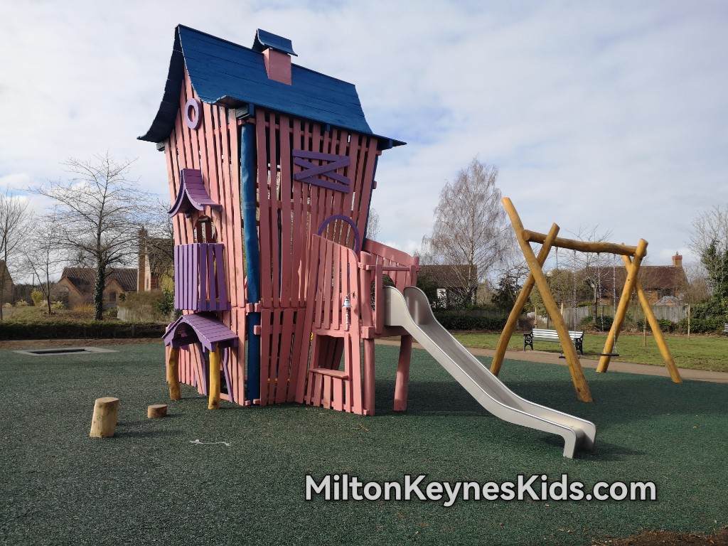 Pink wooden house climbing frame with a small slide